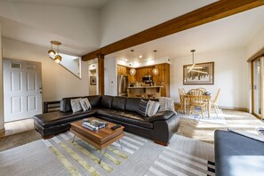 Light and airy living room / kitchen and dining area with stairs going up from the kitchen.