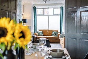The living room leading into the large dining room with a table that can seat up to 6 comfortably.
