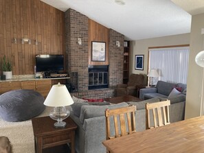 Large, open living room with wrap-around couch and fire place upstairs