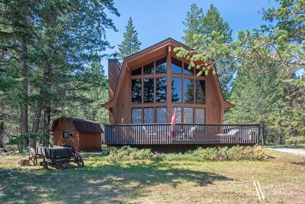 Exterior of Mountain Getaway - surrounded by trees with a private hot tub, fire pit wrap-around deck & more.