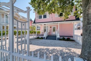 Front of house with porch and fenced in yard to enjoy.