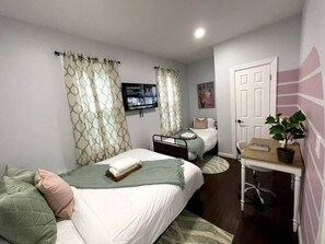 Welcome to our spacious bedroom, thoughtfully designed for comfort and productivity. Two cozy beds provide ample sleeping space, perfect for family or friends. A well-equipped work station offers a dedicated area for focus and creativity. Whether you're unwinding or working, this versatile bedroom ensures a restful and productive stay.