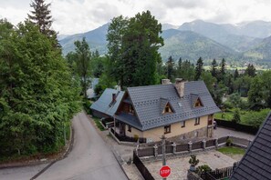 A picturesque aerial shot of the surrounding mountain village, nestled among lush greenery.