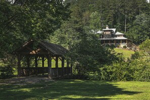 Covered bridge over stream with lodge in the background