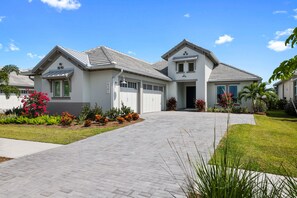Front of home.  3 car garage, pavers, upgraded plantings, spacious covered entry