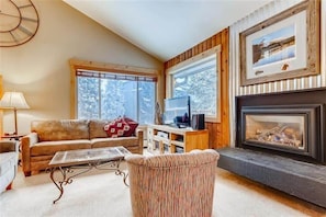 Family room with comfortable furniture, gas fireplace, and flat-screen TV