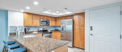 Renovated kitchen w ocean blue backsplash, granite counters,stainless appliances