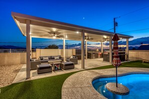 Large covered patio, with BBQ, bar seating, and lounge.