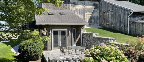 Back patio with grill, table, and a waterfall built into the stone wall!