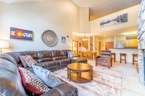 Spacious living area with vaulted ceilings, large flat screen HD TV, gas fireplace, ample seating and access to the private balcony.
