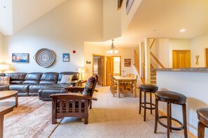 Spacious living area with vaulted ceilings, large flat screen HD TV, gas fireplace, ample seating and access to the private balcony.
