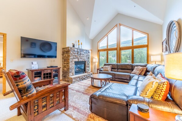 Spacious living area with vaulted ceilings, large flat screen HD TV, gas fireplace, ample seating and access to the private balcony.