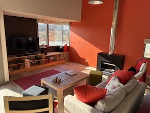 Lounge room with fireplace and TV