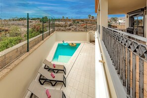 Heated private pool with comfortable sunbeds, back of the villa