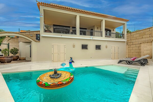 Heated private pool with comfortable sunbeds, back of the villa