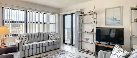 Living room with two couches and chairs with decorative rug.