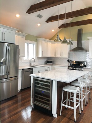 Kitchen including oversized main refrigerator and separate wine refrigerator