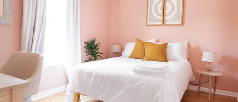 The pink room has a queen bed, full closet, working space and plenty of sunlight!