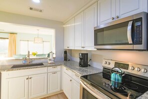 The Aurora features a spacious kitchen with white cabinetry and stainless steel appliances.