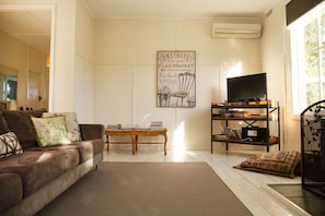 Harvest House living room with wood combustion heater opens to outdoor deck.