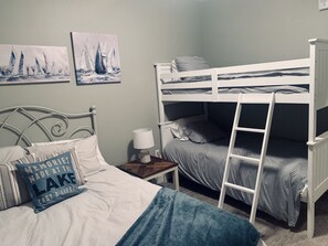 The first bedroom has a queen bed & a set of bunk beds.
