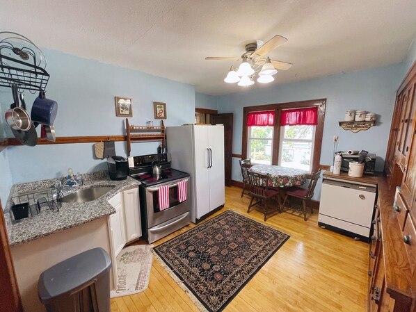 Kitchen with convection oven, fridge, portable dishwasher, and breakfast table.