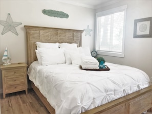 Master bedroom has a Queen sized bed, two night stands, a dresser.