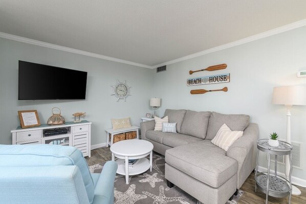 Living room with new sofa queen sleeper (Jan. 2024), recliner, big screen tv