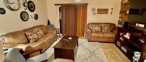 Family room with queen sleeper sofa and love seat and 55" Smart TV.