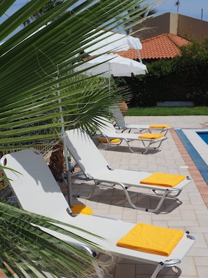 Sun loungers at side of pool