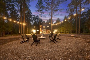 Outdoor fire pit seating with lighting for guests.