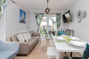 A different angle of the same living room, showcasing the sofa and part of a dining table in the background.