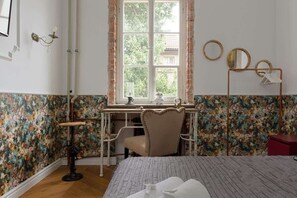 Close-up of the cozy part of the bedroom with the desk and armchair located under the window.