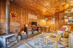 Spacious living room with smart TV and wood burning stove with complimentary firewood.