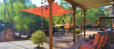 Relax on the deck overlooking the boulders, trees and creek