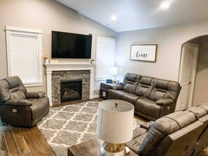 Living Room on the main floor features leather reclining sofas plus chair and a large flat screen TV