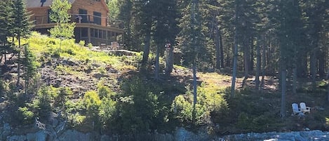 Log cabin above the water overlooking the ocean.