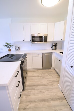 New kitchen fully stocked and ready to use: range, microwave, and dishwasher.