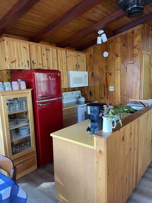 A fully equipped kitchen with new appliances including stove, fridge, microwave.