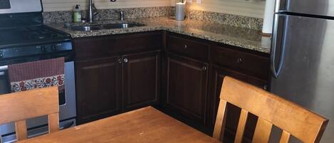 Kitchen with full-sized fridge and stove.