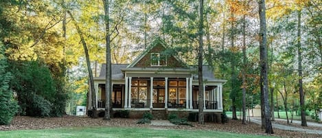 Looking at the house from the lake. Beautiful yard and wrap around porch.