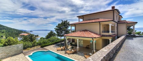 Pool area with sunbeds just meters from the villa.