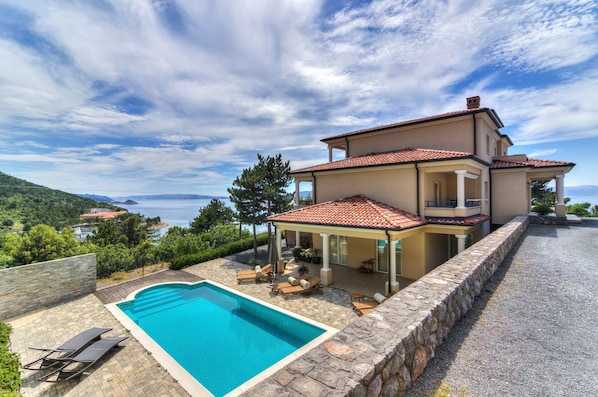 Pool area with sunbeds just meters from the villa.