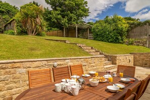 Beadale Cottage, Ampleforth: Outside patio area with steps up the sloped lawn