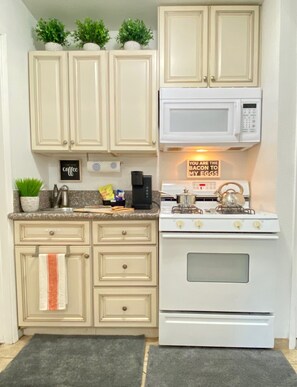 Fully stocked kitchen with oil, spices, cookware, housewares, dishes, silverware