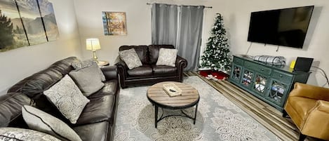 Family room with queen sleeper sofa and love seat and 55" smart TV