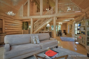 Full size couch faces a gas log fireplace in The Great Room