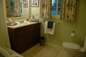 Tub with shower, nice sink, window to outside. Upscale linens/towels.