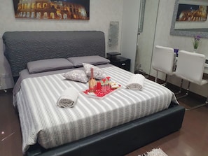 Camera Matrimoniale con Bagno Privato, Frigo, Armadio e Scrivania con Sedie.