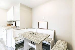 A kitchen and dining area in one, with a cozy table and benches